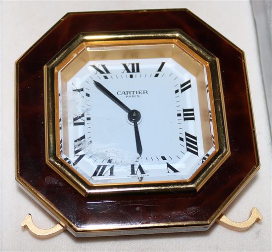 A cased Cartier gilt metal octagonal travelling alarm clock, 3in.